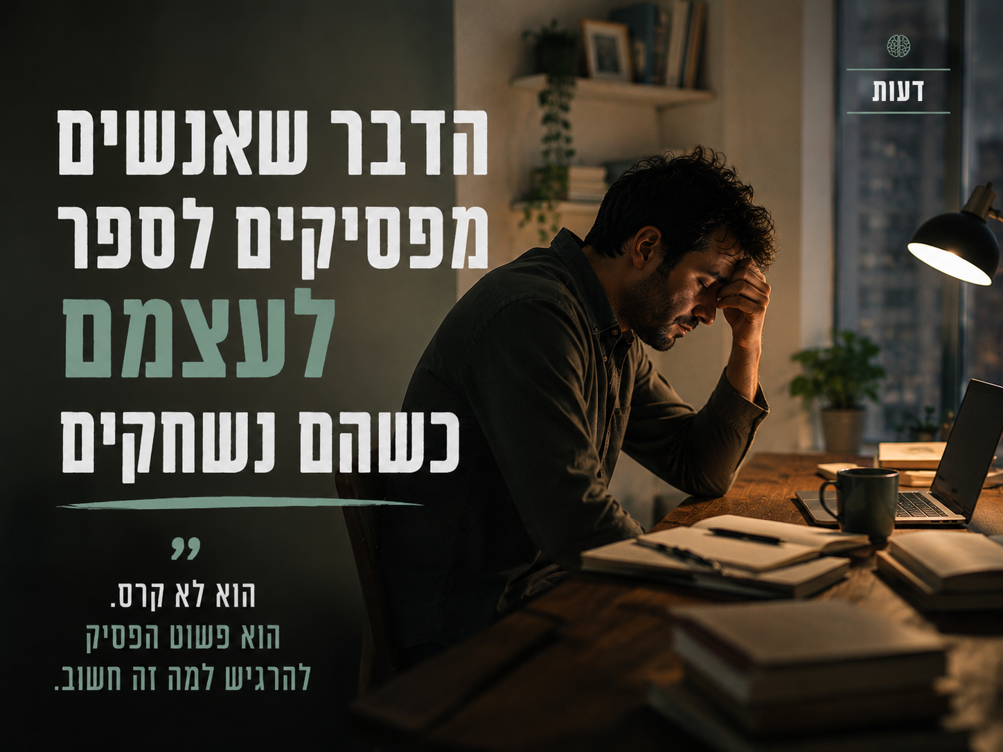 אדם יושב לבד במשרד אחרי שעות העבודה מול מחשב פתוח ומבט עייף